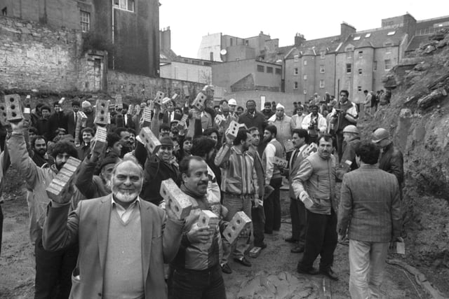 Muslims from Edinburgh and the Lothians gather at land in Potterrow as work begins on their Great Mosque in March 1989. Each man holds bricks for the mosque's foundations.