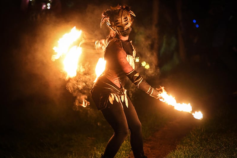 A skilled fire spinner awaits the arrival of the May Queen. Photo: Andy Buchanan / AFP via Getty Images