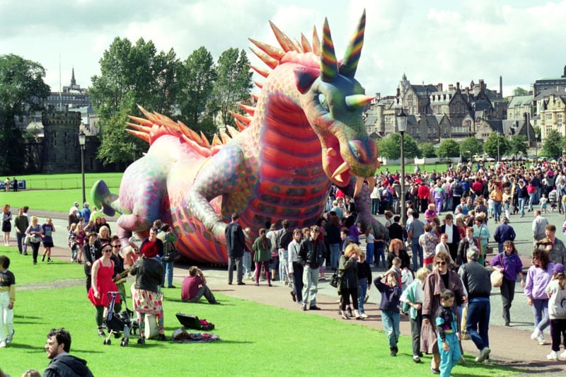 An inflatable dragon hides amongst the crowd at Holyrood Park Edinburgh on Fringe Sunday, August 1992.