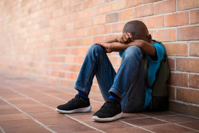 A generic picture of a black schoolboy sitting against a wall. Pic: Rido-Shutterstock