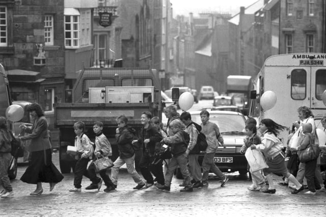 Primary school children dodge the traffic as they try to cross the road at John Knox's house in Edinburgh's Royal Mile, May 1989.