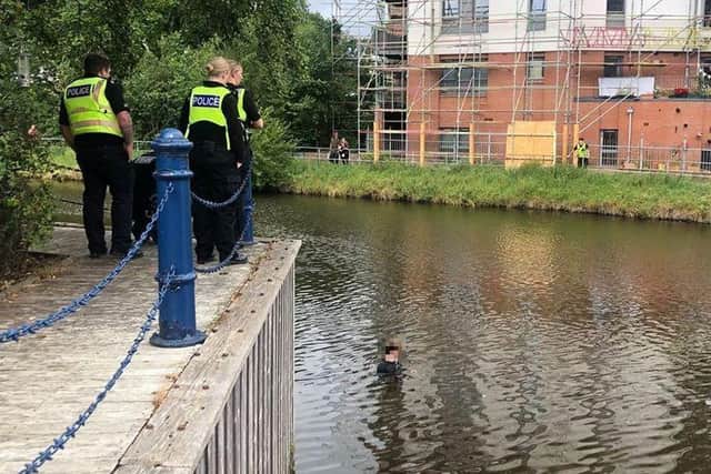 A man stands in the Water of Leith as police officers look on. Photo: Friends of the Water of Leith Basin
