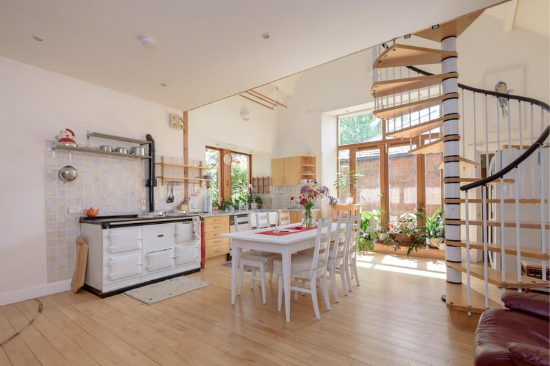 The bright and spacious kitchen/dining room includes a white four oven Aga, a double Belfast sink with marble worktop, and French doors leading to the garden.