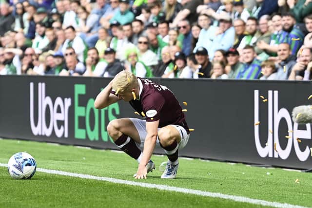 Alex Cochrane of Hearts is hit by objects from the home support at Easter Road in August.