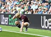 Alex Cochrane of Hearts is hit by objects from the home support at Easter Road in August.