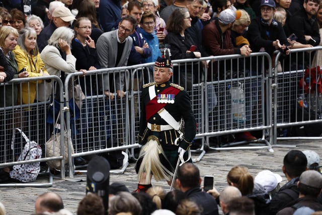 A soldier walks near Mercat Cross ahead of the procession of Queen Elizabeth II's coffin from the Palace of Holyroodhouse to St Giles' Cathedral, Edinburgh, following her death on Thursday. Picture date: Monday September 12, 2022.