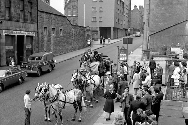 A stagecoach and four horses sets off from a bus stop in the Royal Mile Edinburgh on its way to Holyrood Park as part of a charity drive in June 1971.