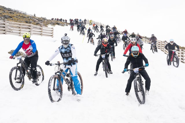 Cyclists take part in MacAvalanche, a mass start mountain bike race through the snow, descending over 900m from the summit of Aonach Mor in the Nevis Range near Fort William. Jane Barlow/PA Wire