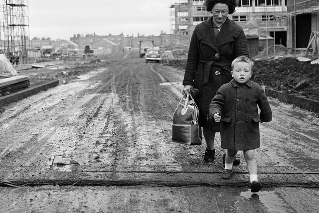 Norma Dickson and her son walk through a muddy Muirhouse street in November 1964. Residents were complaining about the state of the area.