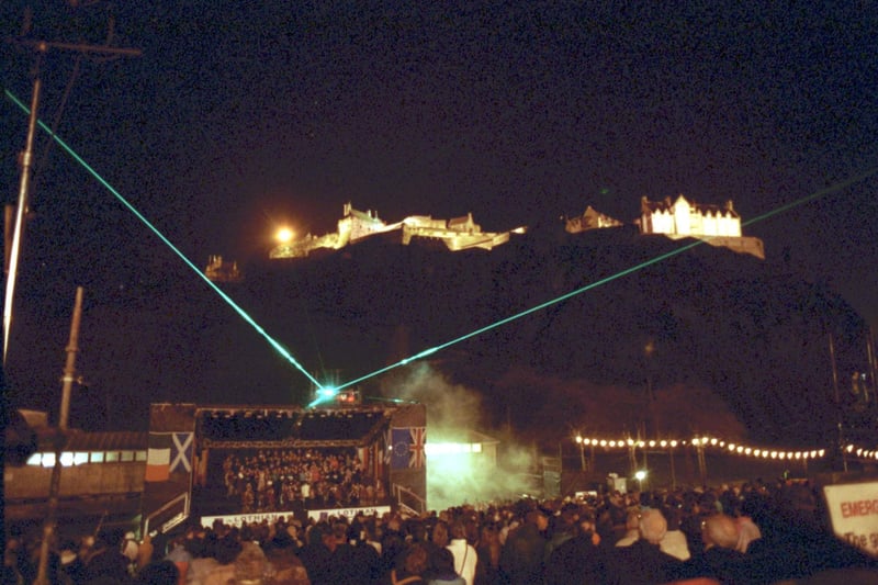 A laser show lights up the night sky on Hogmanay 1992, as crowds gather on Princes Street Gardens.