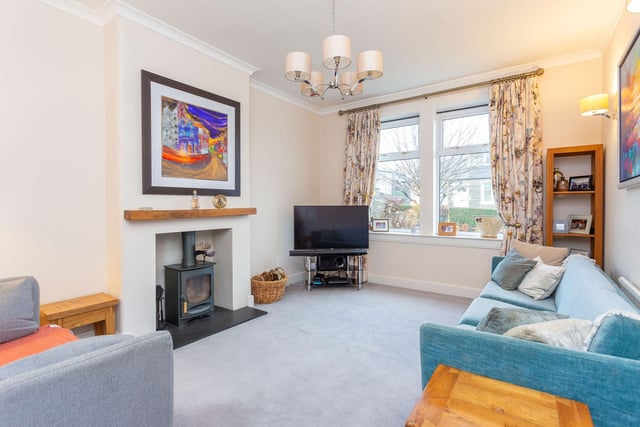 The property includes a bright living room with attractive neutral décor including grey carpeting and desirable log-burning stove set into a hearth.