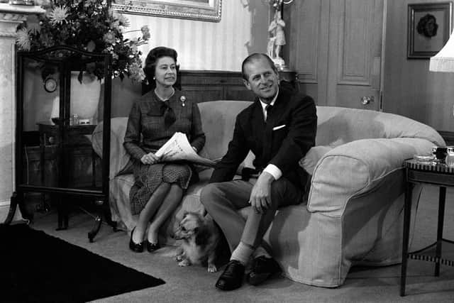 Queen Elizabeth II and the Duke of Edinburgh during their traditional summer break at Balmoral Castle. The royal couple are seen with 'Tinker', a cross between a corgi and long haired dachshund.