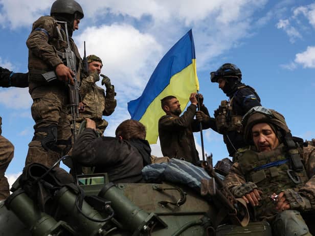 Ukrainian soldiers raise their national flag on an armoured car near Lyman, Donetsk region (Picture: Anatolii Stepanov/AFP via Getty Images)