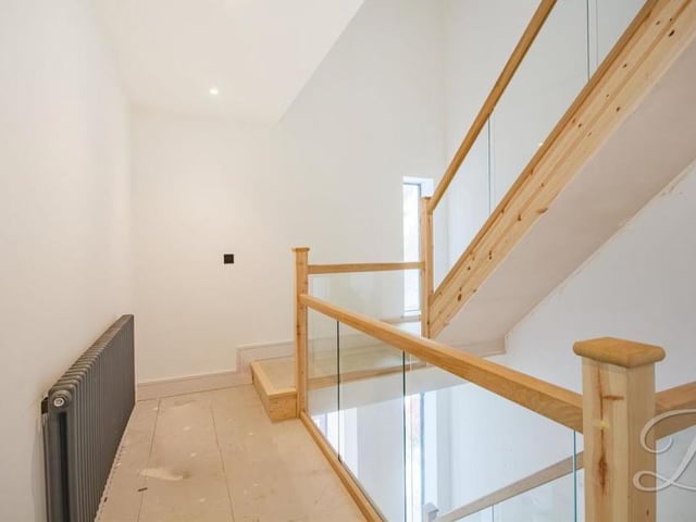 We're heading upstairs now, which means negotiating the landing. It boasts a glass balustrade and gives access to the five bedrooms.