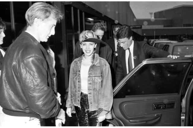 Australian pop singer Kylie Minogue smiles for the photographer before getting into her car in Edinburgh Airport in October 1989.