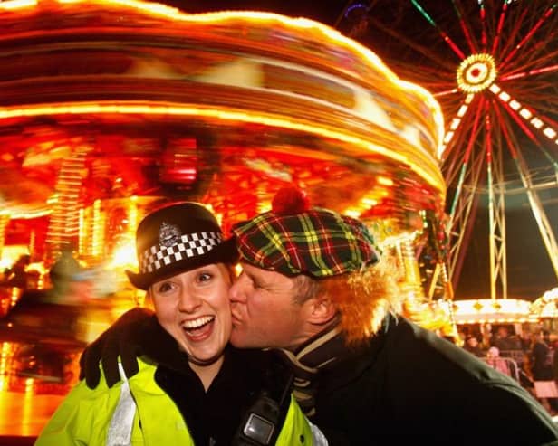 Police constable Lee Dingsdale receives a kiss from Aiden Cooper as revellers take to Princes Street to celebrate New Year on December 31, 2008.