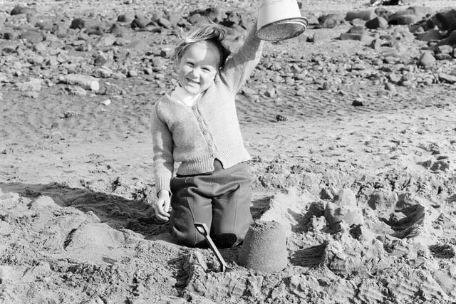 A little girl shows off her sandcastle on Portobello Beach in July 1965.