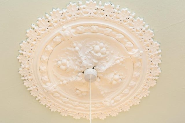 The property boasts a variety of charming period features including detailed cornicing and a ceiling rose in the living room.