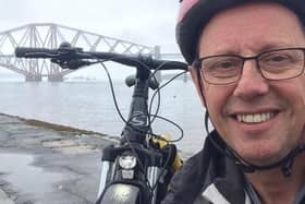 Bruce Whitehead poses for a selfie with his electric bike and the Forth Bridge in the background