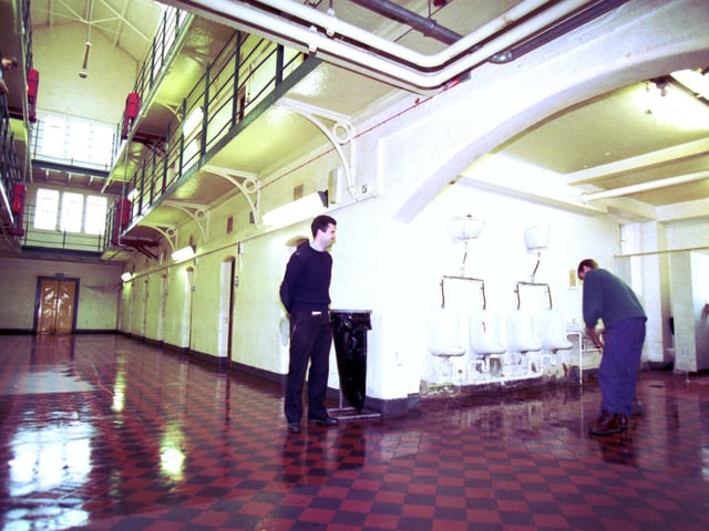 A prisoner washes the bathroom floor at Saughton jail in Edinburgh, May 1993.