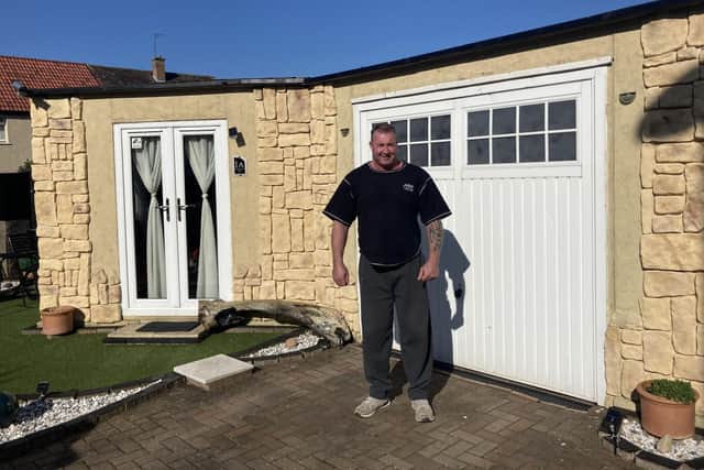 James Bevis in front of the sunroom and garage at his home in Mayfield.