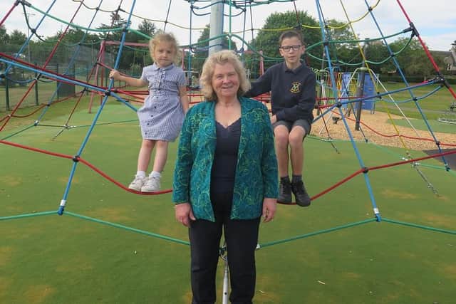 Cllr Alexander is pictured with Sofia and Leonardo, on the new play equipment at King's Park, Dalkeith.