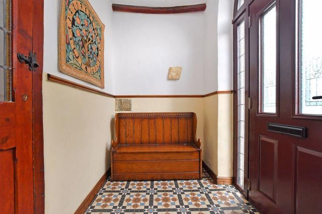 A traditional monks bench has been positioned in the entrance lobby, which also contains a tiled floor and exposed roof timbers.