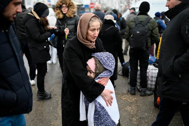 A woman hugs a girl as refugees from Ukraine wait for transport at the Moldova-Ukrainian border near the town of Palanca (Picture: Nikolay Doychinov/AFP via Getty Images)