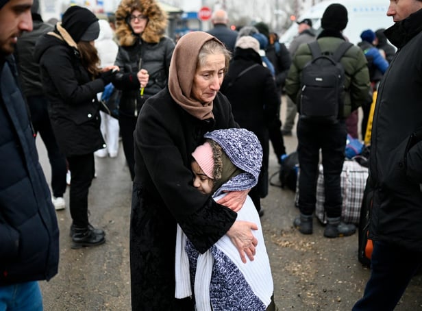 A woman hugs a girl as refugees from Ukraine wait for transport at the Moldova-Ukrainian border near the town of Palanca (Picture: Nikolay Doychinov/AFP via Getty Images)