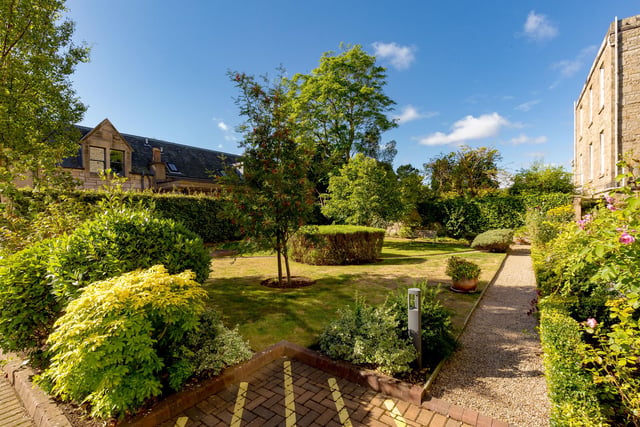 The well-kept communal gardens laid to lawn with mature borders.
