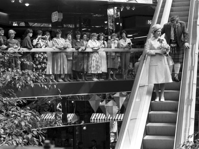 Queen Elizabeth II officially opened the Waverley Market shopping centre in Princes Street Edinburgh, July 1985. The Queen comes down the escalator.