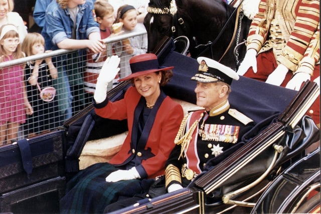 The State Visit of King Harald of Norway to Edinburgh took place in July 1994 . Queen Sonja is pictured waving to the crowds from a Royal coach while sitting next to Prince Philip Duke of Edinburgh.
