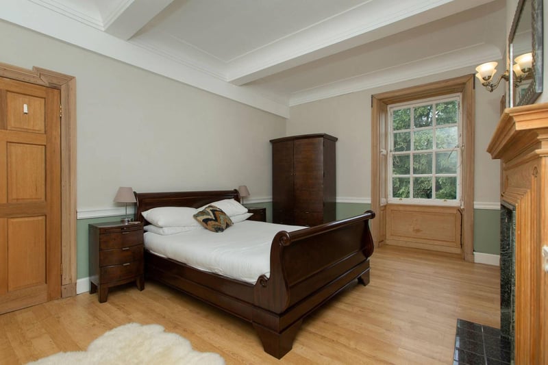 The master bedroom features a beautifully restored fireplace and high moulded ceiling.