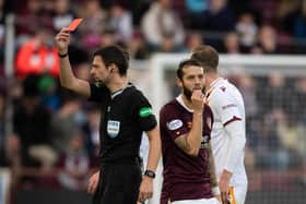 Referee Kevin Clancy shows Hearts midfielder Jorge Grant a red card.
