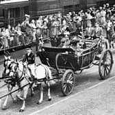 In October 1962, Queen Elizabeth II and King Olav of Norway make their way up Lothian Road in the Royal Coach during the state visit to Scotland.