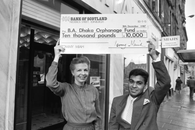 Edinburgh businessman and Indian restaurant owner Tony Miah presents a £10,000 cheque to British Airways stewardess Pat Kerr for the BA Dhaka Orphanage Fund in December 1987.