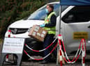 Staff from the Scottish Ambulance Service carry boxes of test kits from a van at a Covid Mobile Testing Unit in a car park in the Pollokshields area of Glasgow. Glasgow and Moray remain in Level 3 restrictions despite the rest of mainland Scotland moving to Level 2 on Monday. Picture date: Tuesday May 18, 2021.