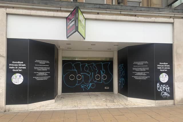 An empty shop tagged with graffiti In Princes Street