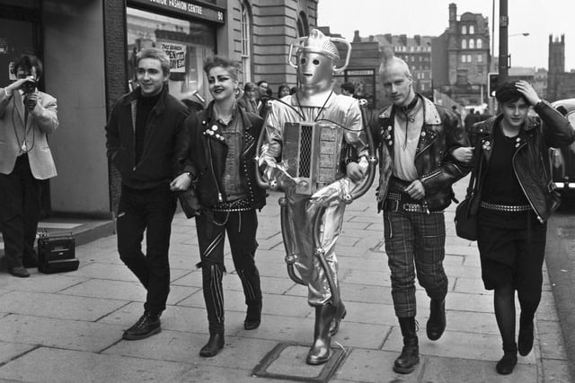 Punks and a Cyberman walking up Lothian Road to publicise the 20th anniversary Dr Who exhibition at the Filmhouse cinema in Edinburgh, December 1983.