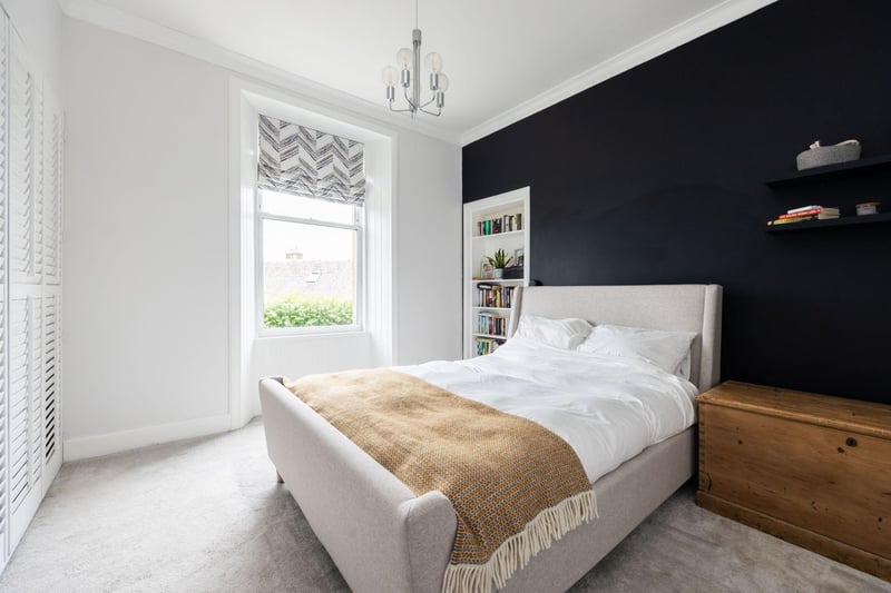 The master bedroom features desirable elements such as large windows with views of the Forth, built-in wardrobes, and an Edinburgh Press.