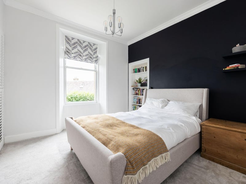 The master bedroom features desirable elements such as large windows with views of the Forth, built-in wardrobes, and an Edinburgh Press.