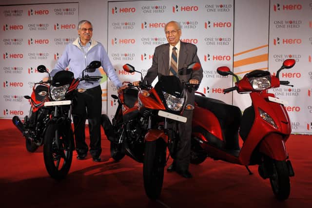 Founder and chairman Hero Motocrop Brij Mohan Lall Munjal (R) and then joint managing director Hero Motocrop Sunil Kant Munjal pose with newly launched products at a function in New Delhi in 2012.