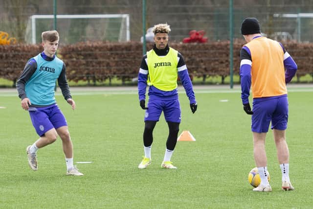 Oscar MacIntyre, left, participates in Hibs first-team training at HTC