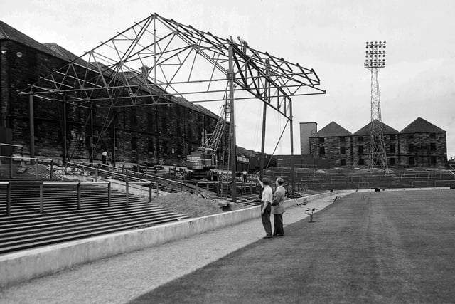 A new covered enclosure under construction, 10 July 1959. The warehouses of the neighbouring North British Distillery can be seen in the background.  This work was paid for by the sale of club legend Dave Mackay for £32,000 to Tottenham Hotspur.