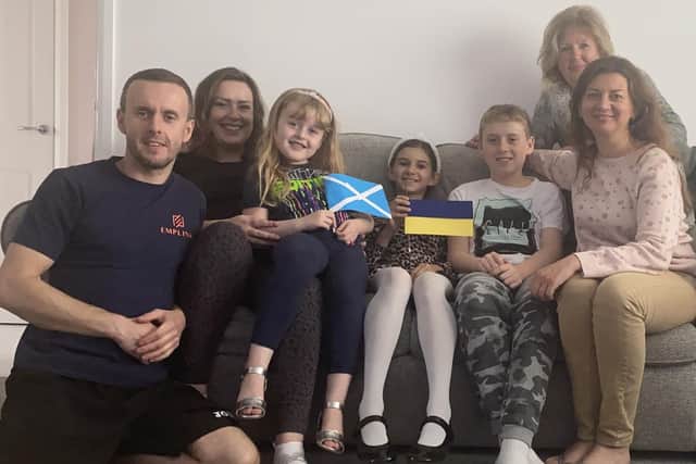 L to R:Damian and Jennifer Gad, with Niamh on her lap. Alisa, Tomasz, Viktoriia and Valentyna (at back) at home in Bonnyrigg.