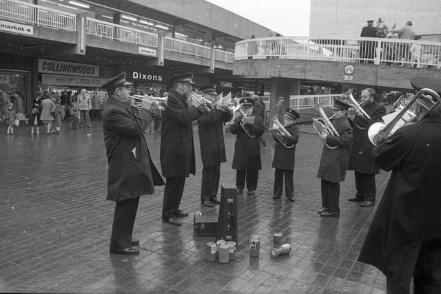 A Salvation Army band braves the elements to entertain the shoppers at Hartlepool shopping centre.  Behind are Collingwoods, Dixons and Samuel's shops. How much has this scene changed?