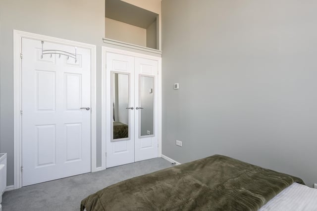 The stylish grey décor bedroom features built-in wardrobes and an additional storage space as well as plush carpet flooring 
Photo: Neilsons and Planography