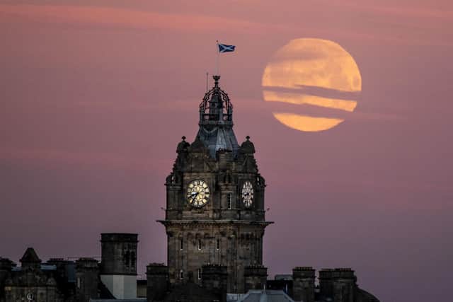 The moon sets behind the Balmoral Clock in Edinburgh. Photo: Jane Barlow/PA Wire.