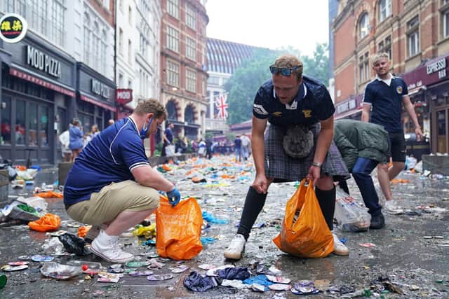 Scotland fans clean up litter in Irving Street  near Leicester Square, London  (Pic: Kirsty O'Connor/PA Wire)
