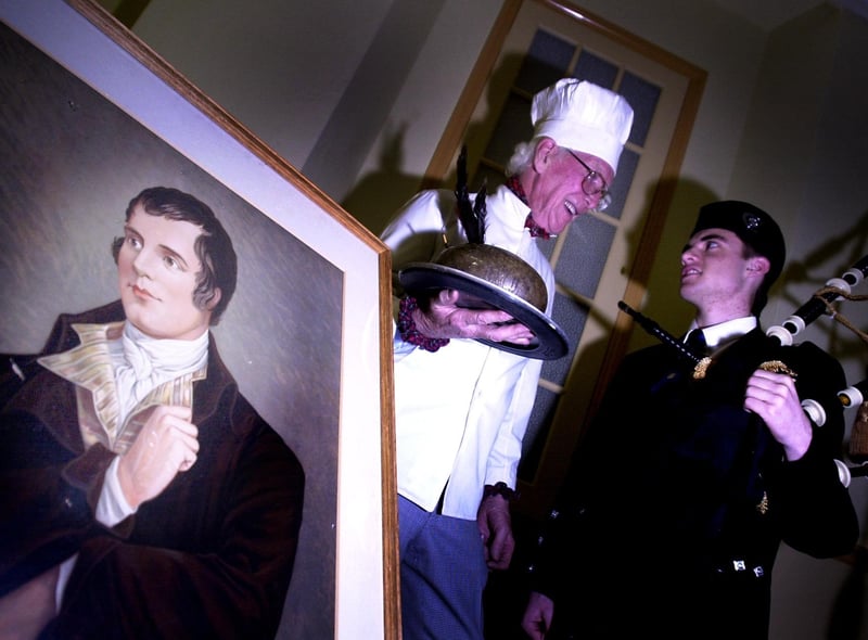 A 17-year-old piper chats with the chef, next to a picture of Robert Burns, at the Kirk O'Field Parish Church Social Club Burns Supper in 2002.